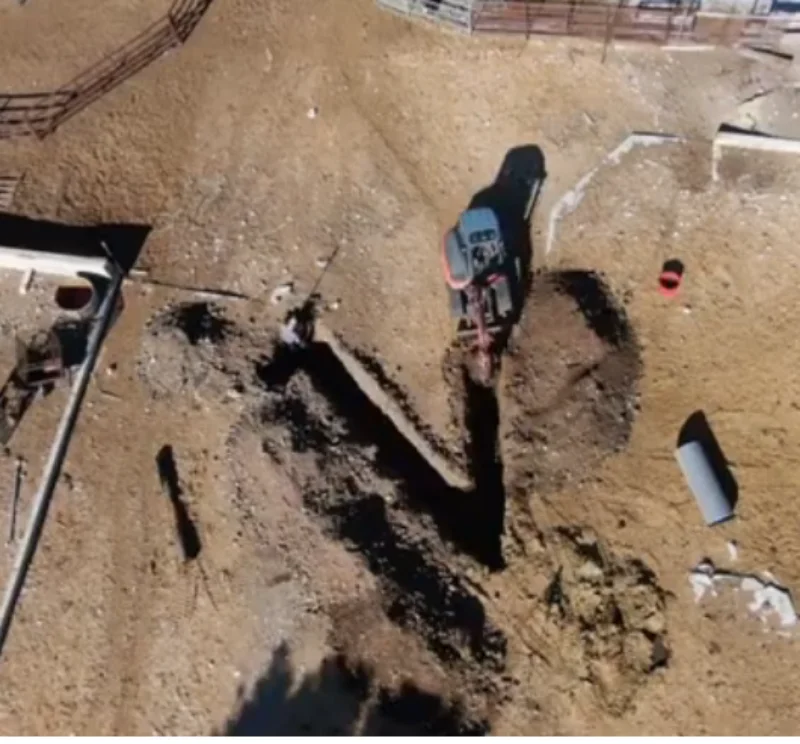 Sewer line replacement in Greeley, CO: aerial view of a mini excavator digging the trench for a new line