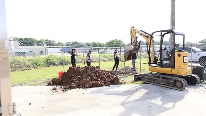 Sewer line repair cost in Greeley: crew and a mini excavator opening a trench for a sewer job
